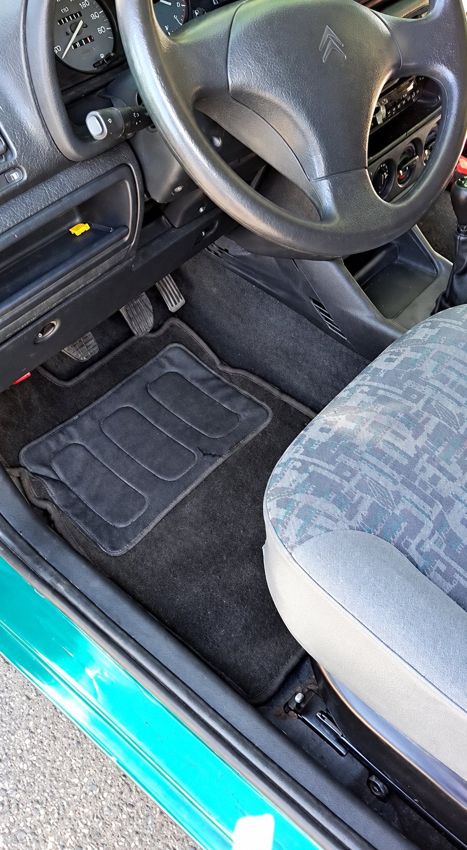 Habitacle d'une Citroën verte, tapis de sol et volant avant nettoyage